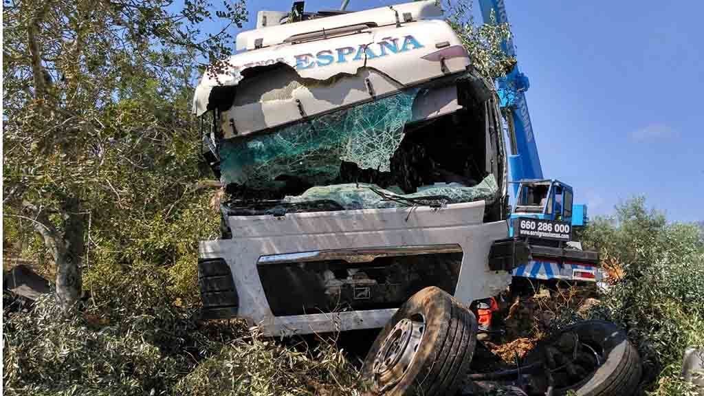 La grua treballa per aixecar el camió accidentat la matinada de divendres a la Ràpita